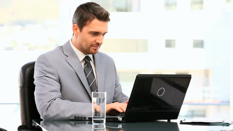 Young Business Executive Working at Office Desk with Laptop