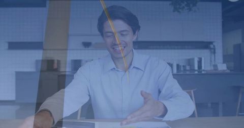 Smiling professional gesturing toward documents while using smartphone in modern kitchenette