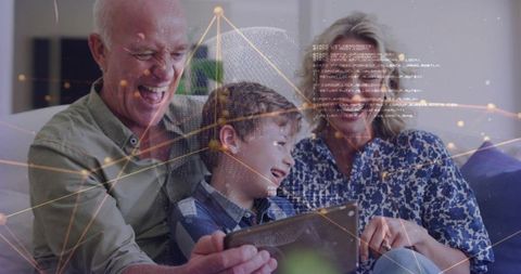 Laughing grandparents and grandson watching tablet on sofa with digital network overlay
