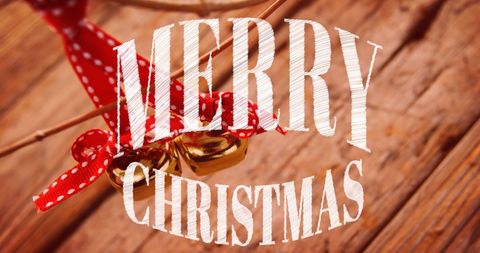 Festive merry christmas text with holiday bells and wood background