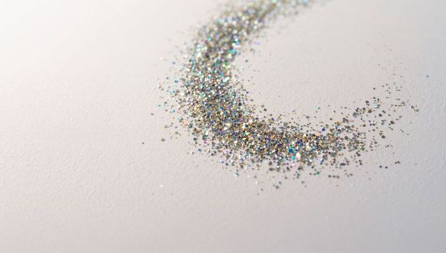 Holographic silver glitter crescent on off-white cardstock with rainbow sparkle