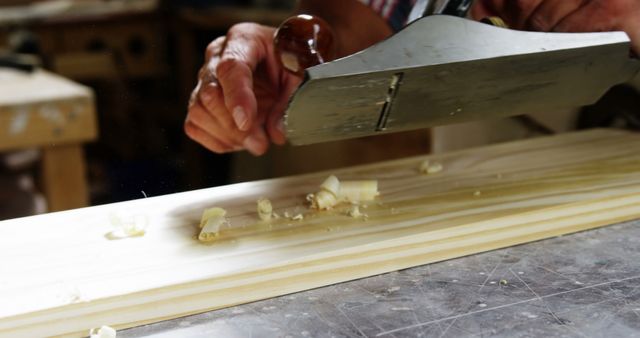 Craftsman Using Hand Plane on Wooden Plank in Workshop - Download Free Stock Images Pikwizard.com