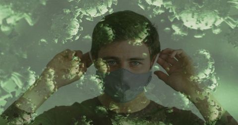 Young man adjusting protective mask with virus overlay double exposure pandemic concept