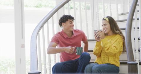 Happy Couple Enjoying Coffee on Stairs at Home