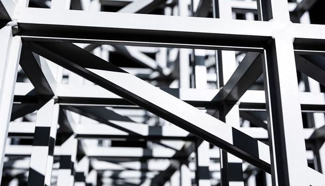 Forming geometric steel lattice casting bold diagonal shadows and repeating grid