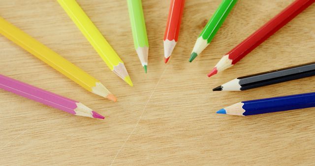Colored pencils are arranged in a semi-circle on a wooden surface, with copy space - Download Free Stock Photos Pikwizard.com