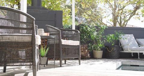 Cozy outdoor patio with wicker seating by poolside for relaxation