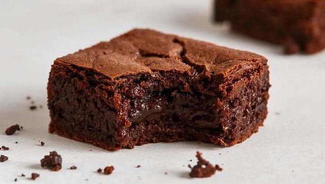 Gooey Chocolate Brownie Revealing Molten Center with Crumbs on Parchment