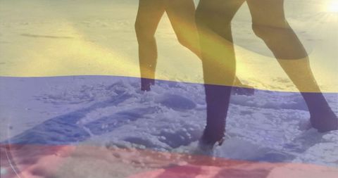 Couple walking into surf at golden hour on beach with tricolor overlay and backlit legs