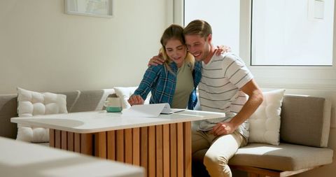 Couple Enjoying Morning Coffee Reviewing Documents at Home
