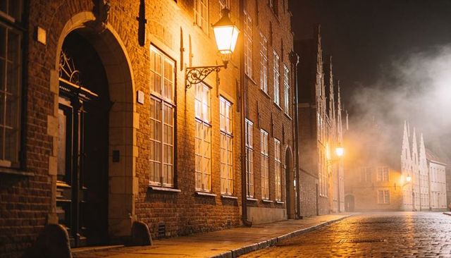 Glowing historic brick facades and wet cobblestone under vintage streetlamps at night