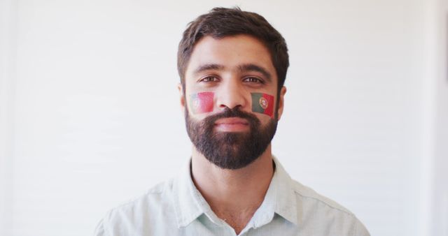 Image of happy middle eastern man with flag of portugal cheering. Sport, cheering and patriotism concept.