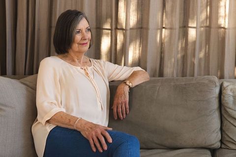 Senior woman relaxing thoughtfully on sofa at home