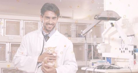 Male veterinarian cradling orange tabby kitten smiling in clinic with stethoscope
