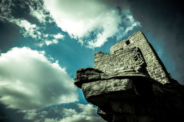 Depicts a centuries-old stone fortress standing strong against a dramatic sky with clouds. Might be useful for history buffs, educational materials on medieval architecture, travel brochures, or themed storytelling.