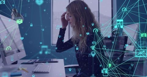 Woman rubbing forehead at desk with digital network overlay depicting tech fatigue