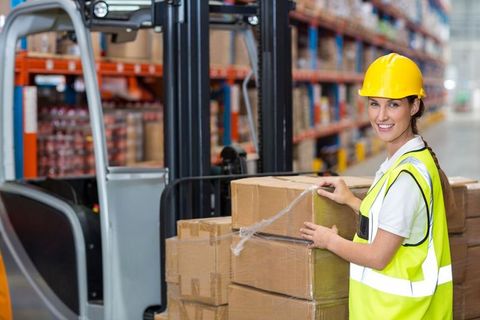 Warehouse Worker Organizing Boxes Using Forklift