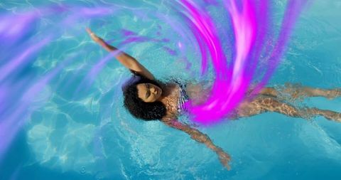 Woman floating on pool back drifting with magenta ribbon motion, sunlit water reflections