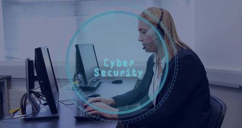 Female it support specialist typing at dual monitors with cybersecurity hud overlay