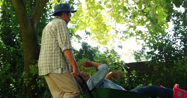 Senior Man Wheeling Playful Child Outdoors in Park - Download Free Stock Images Pikwizard.com