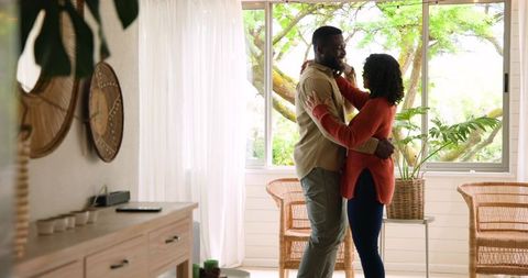 Diverse Couple Embracing by Bright Window Enjoying Morning