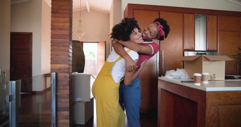 Happy diverse couple unpacking in new home kitchen