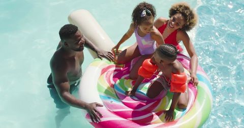 Happy african american family enjoying pool time fun together