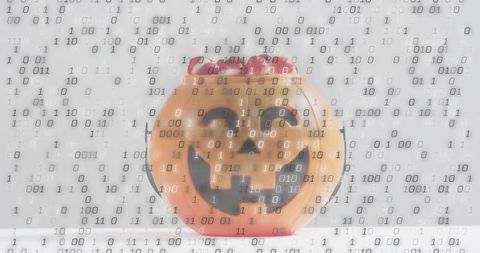 Glossy jack-o-lantern bucket sitting on white table with red sweets and binary overlay