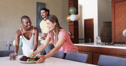Friends preparing food and enjoying casual gathering in kitchen