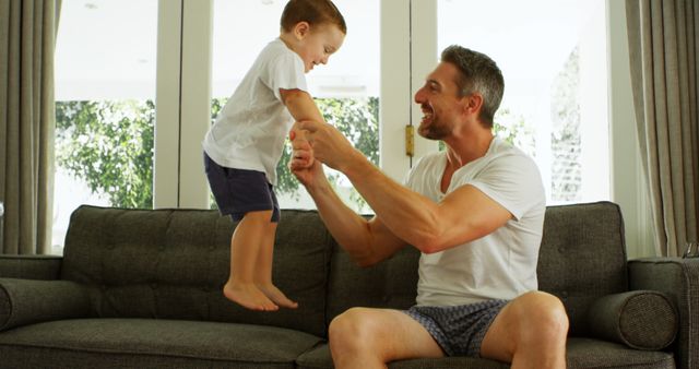 Happy Father Playing with Son on Sofa in Bright Living Room - Download Free Stock Images Pikwizard.com