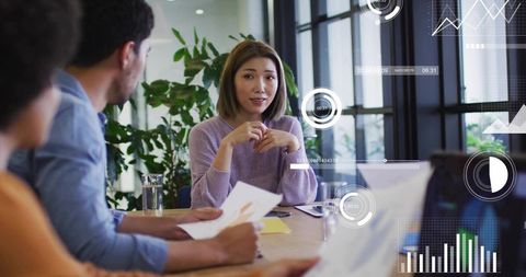 Diverse team collaborating around conference table with data overlays, charts and analytics