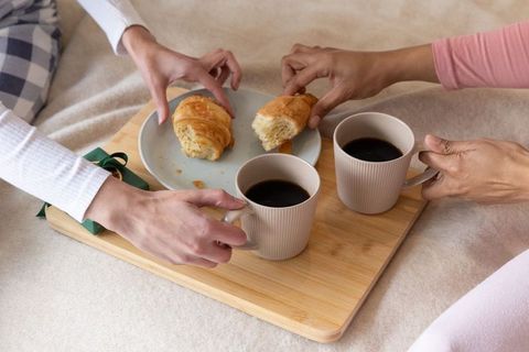 Sharing Morning Coffee and Croissants on Bed Tray with Wrapped Gift for Cozy Moments