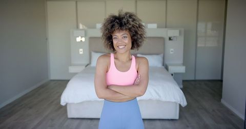 Confident Woman in Activewear Standing in Modern Bedroom