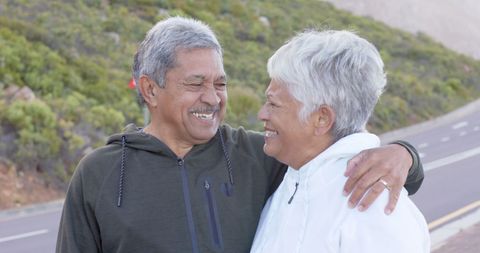 Joyful Senior Couple Embracing on Mountain Road Journey