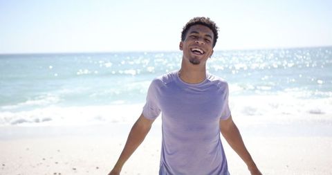 Young Man Enjoying Refreshing Day at Sunny Beach - Download Free Stock Images Pikwizard.com