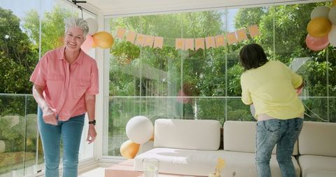Smiling Couple Decorating for Birthday Celebration at Bright Venue