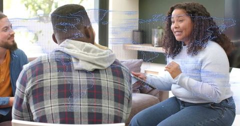 Woman Presenting Tablet to Team in Casual Coworking Lounge with Digital World Map Overlay