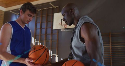 Basketball Coach Mentors Young Athlete with Stopwach in Gym