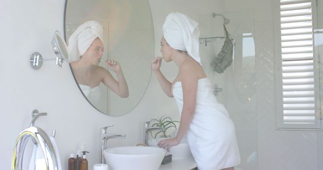 Woman Brushing Teeth in Modern Bathroom Wrapped in Towels - Download Free Stock Images Pikwizard.com