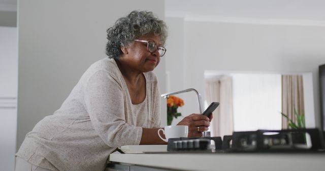 Elderly Woman Using Mobile Phone in Kitchen  - Download Free Stock Images Pikwizard.com