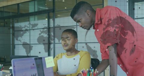 Colleagues Collaborating in Modern Office on Laptop with World Map Overlay