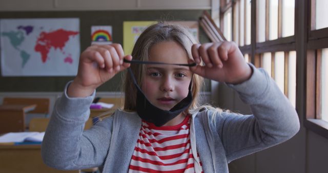 Primary School Girl Removing Face Mask in Classroom - Download Free Stock Images Pikwizard.com