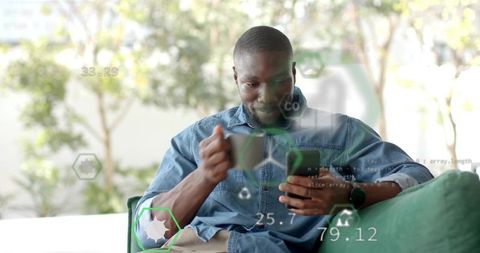 Man Holding Mug and Checking Smartphone with Augmented Reality Data Overlays at Home
