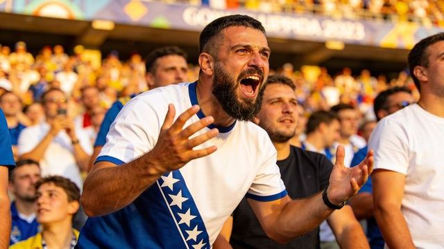 Passionate fan shouting and cheering in stadium wearing blue white star stripe shirt