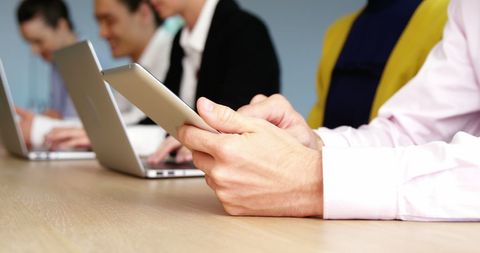 Business Team Using Tablet and Laptops at Meeting