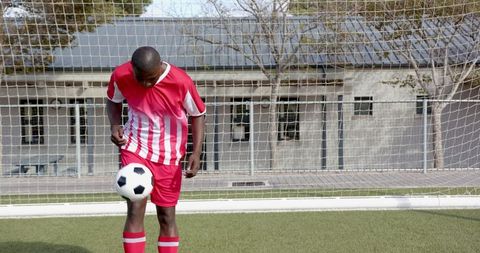 Youth Soccer Player Juggling Ball in Uniform on Artificial Turf