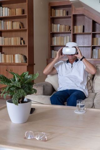 Senior exploring virtual reality in cozy home library wearing vr headset
