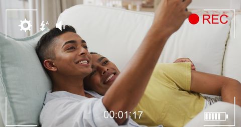Joyful Biracial Male Couple Recording Video Selfie at Home