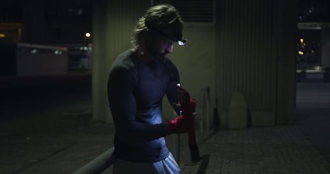 Nighttime Workout: Man Wrapping Hands with Headlight Glow