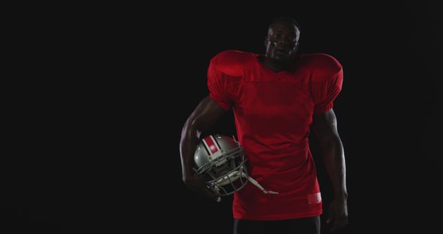 Focused American Football Player in Red Jersey Holding Helmet - Download Free Stock Images Pikwizard.com